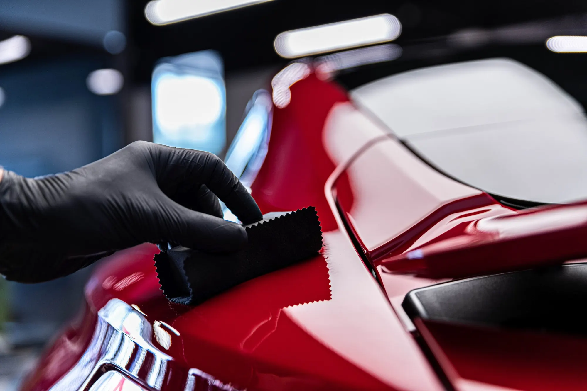 Professional applying ceramic coating to a vehicle.